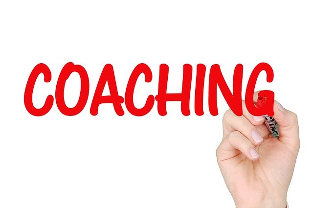 main ecrit le mot coaching en rouge coaching en entreprise