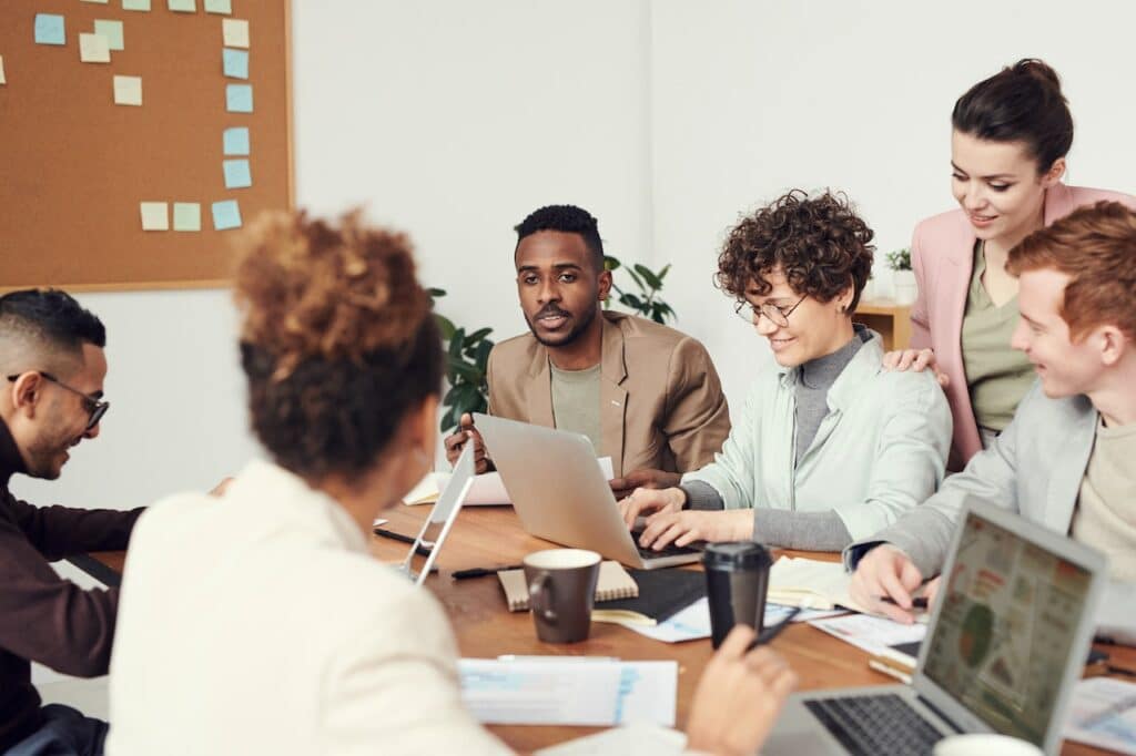 équipe en réunion avec ordinateurs cohésion d'équipe développer les soft skills