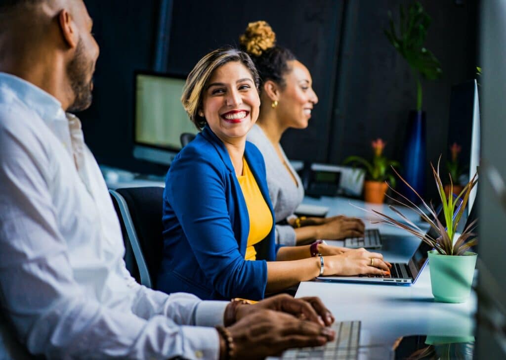 femme au travail sourit à son collègue, développer les soft skills