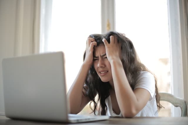 femme qui se tire les cheveux devant son ordinateur semble stressée entreprendre au féminin défis